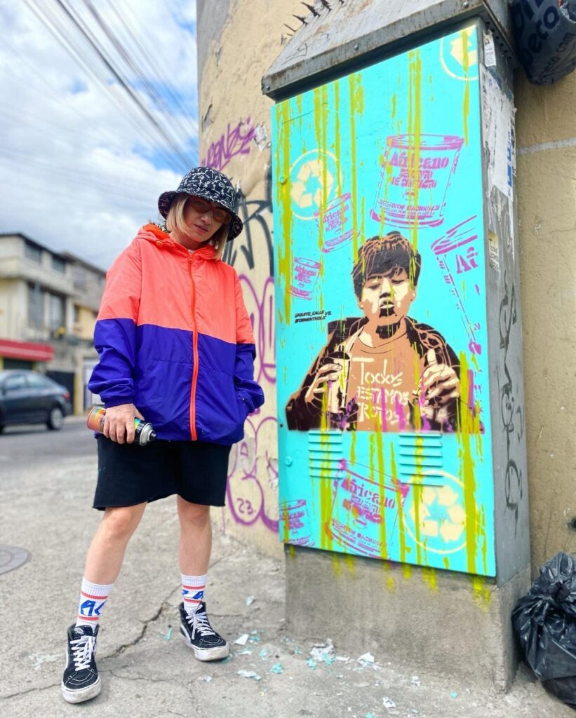 Artista callejera posando con su obra