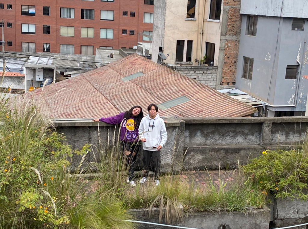 dos personas jovenes posando en la terraza de un lugar abandonado